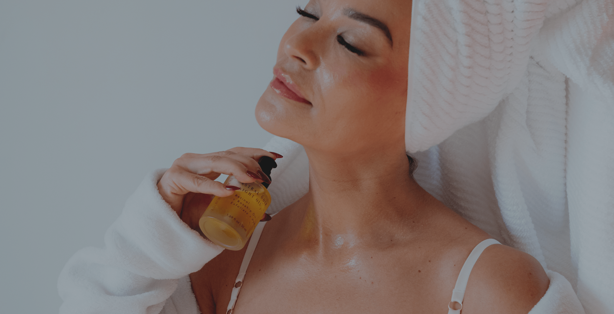 Woman applying oil to her neck with a white background