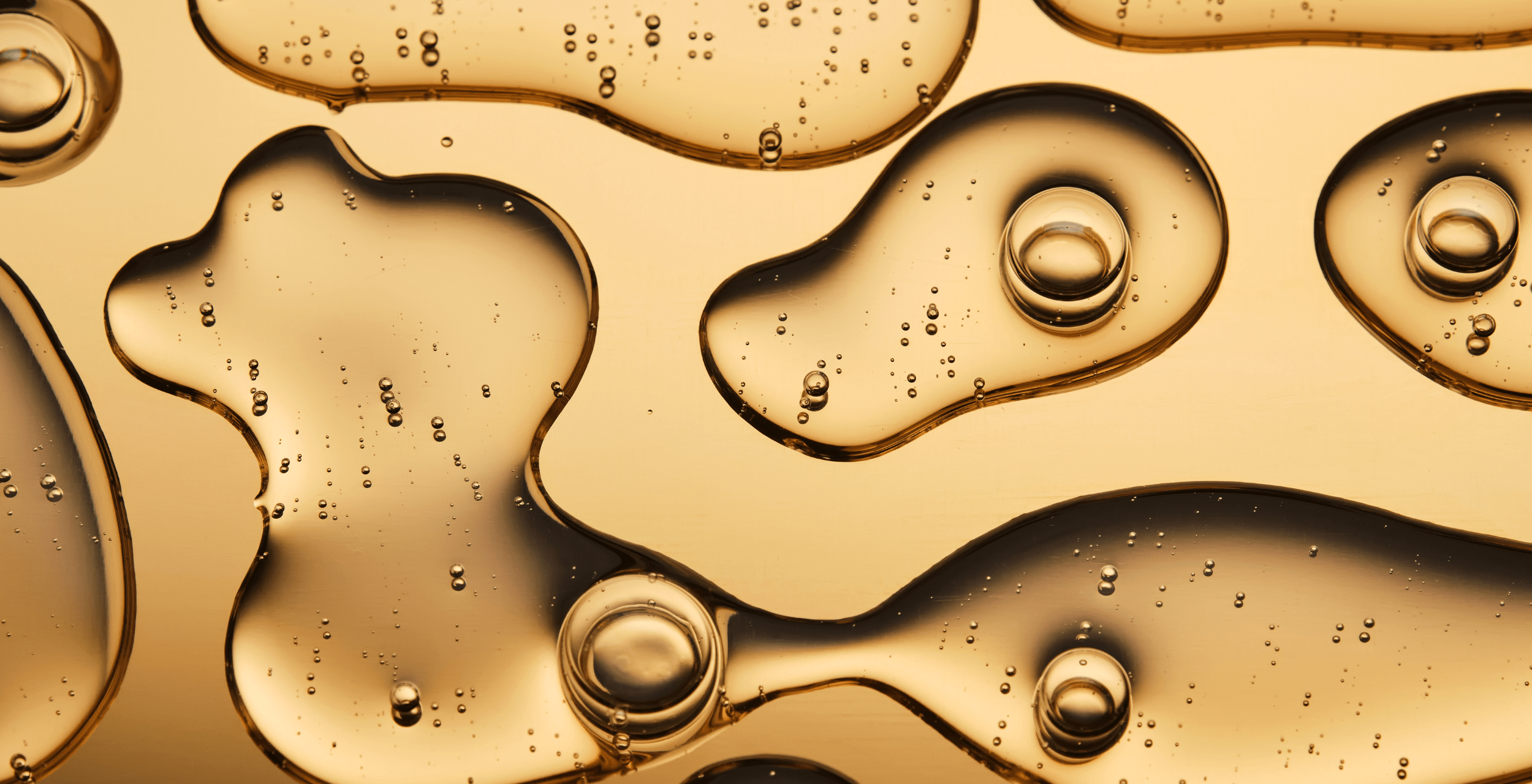 Close-up of gold liquid with bubbles and reflections