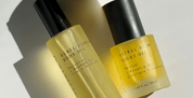 Two yellow bottles of Rebel Radiance Body and Astral Noir body oils on a light background